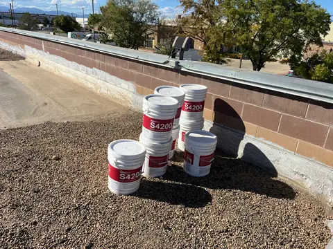 Coating staged on the roof (Cool Roof Coating, North Denver)
